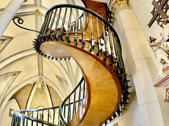 Un escalier en colimaçon en bois à l'intérieur d'une église, connu sous le nom d'escalier de la Loretto Chapel.