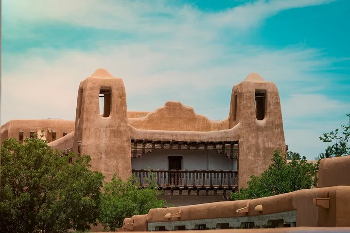 Une vue de près d'un bâtiment traditionnel de style adobe avec un balcon en bois.